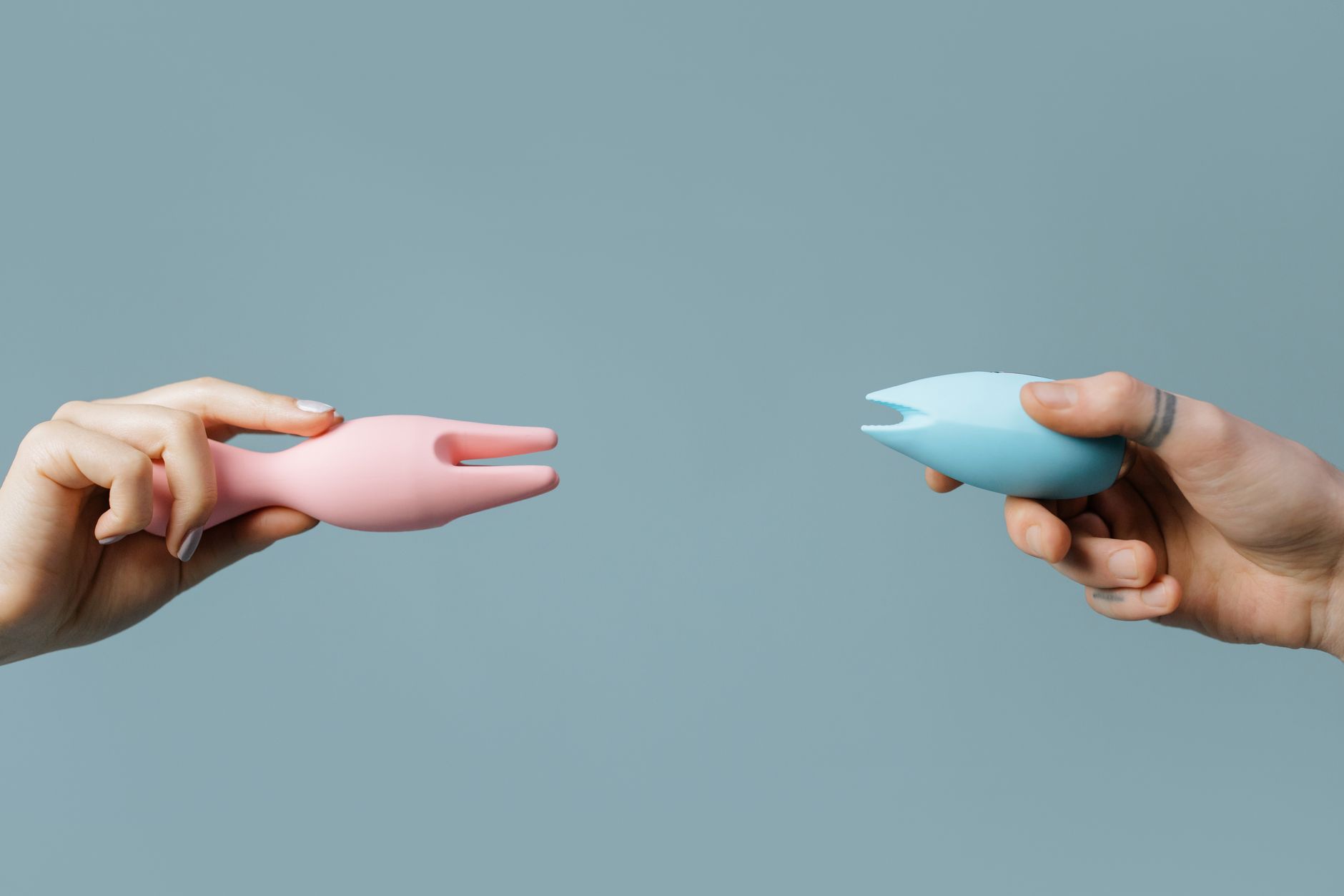 Intimate close-up of hands holding a sleek vibrator, representing gentle reconnection with pleasure after loss.