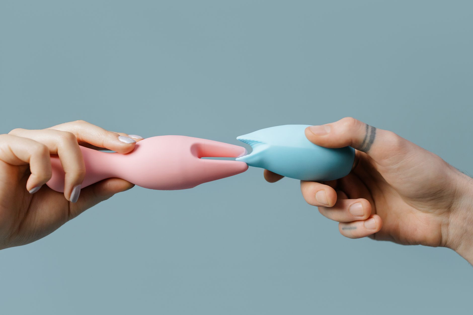 Hand holding a fresh lemon on soft pink background